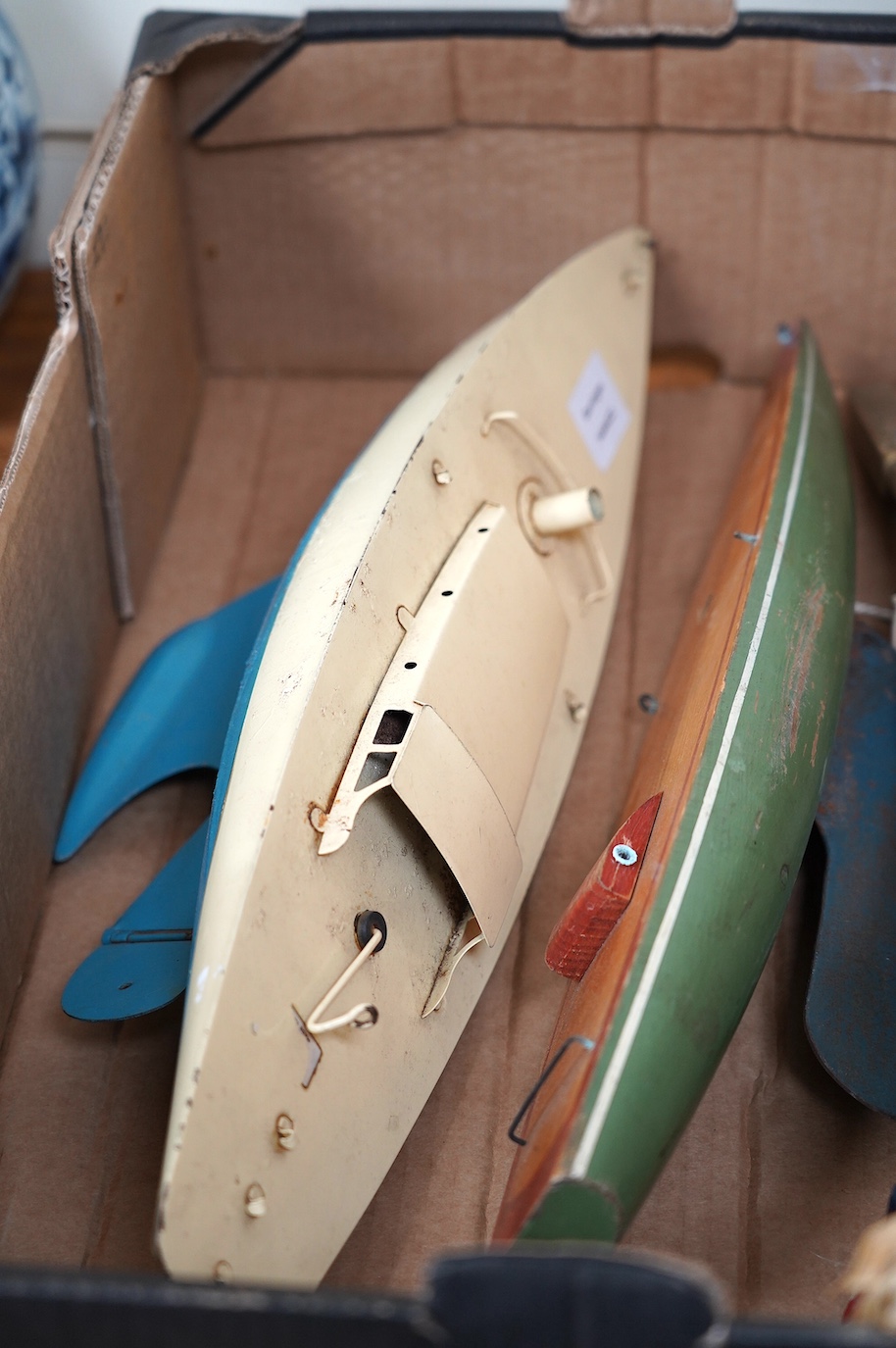 Two Tri-ang pond yachts, one painted tin plate, the other painted wood, together with various masts and flags. Condition - poor to fair